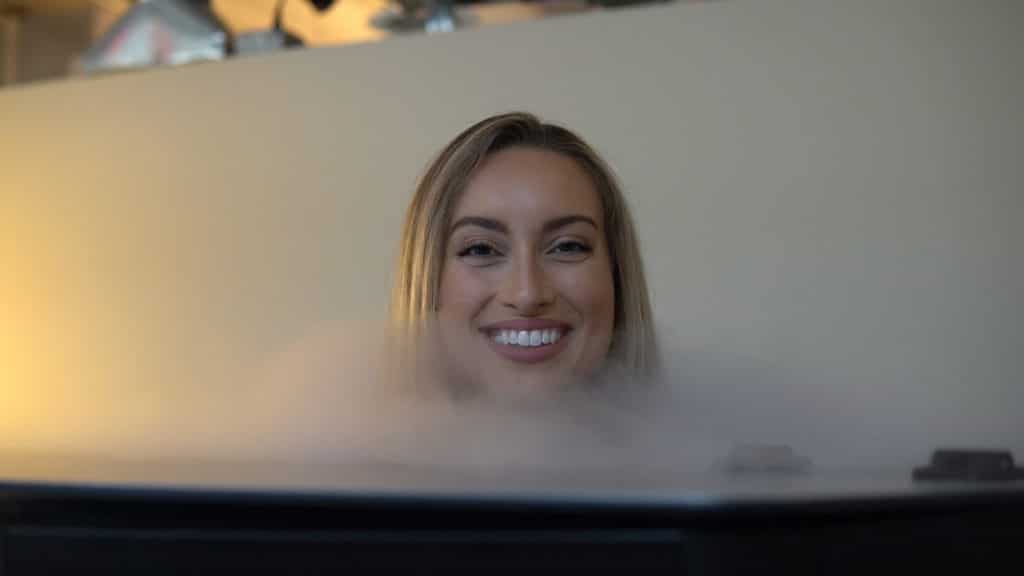 Happy woman receiving cryotherapy treatment at LuxCryo