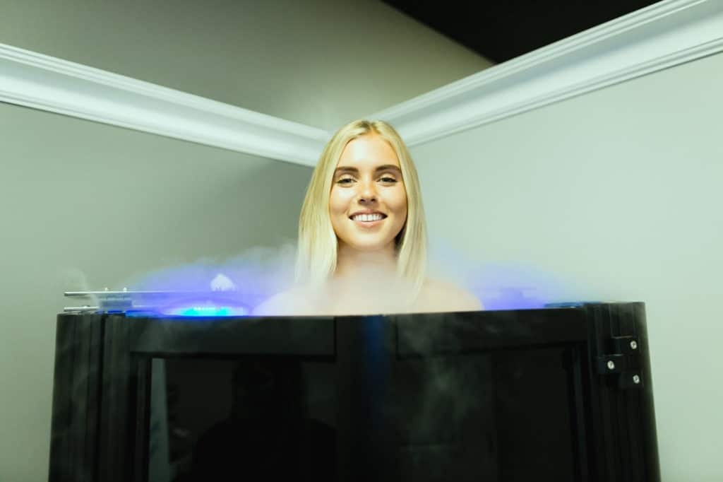Happy Woman in Cryotherapy chamber at LuxCryo